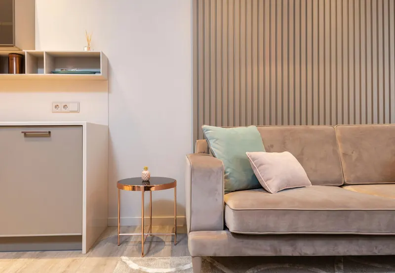 Salón de un alojamiento turístico con sofá y pared de lamas